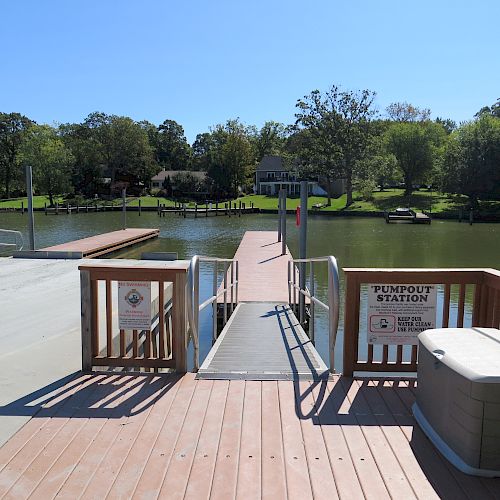 A wooden dock extends into a calm lake with a sign reading 