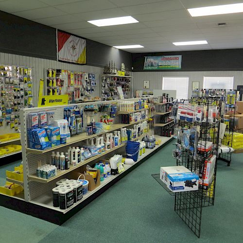 This image depicts the interior of a store with shelves stocked with various products. The shelves contain cleaning supplies, tools, and household items.