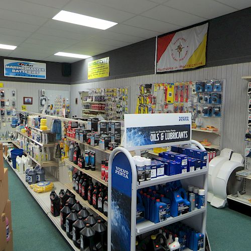 The image shows the interior of a store selling marine supplies, including oils, lubricants, and various boating accessories displayed on shelves and walls.